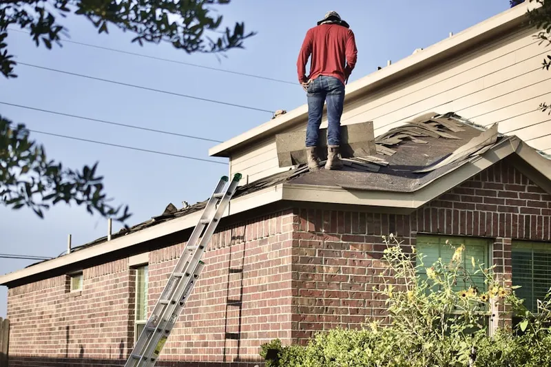 Professional roofer working on a residential roof in Old West Side